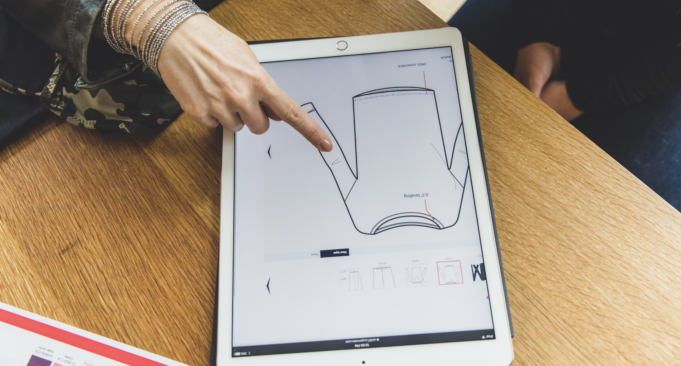 woman pointing at an ipad screen with a drawing of a technical sketch