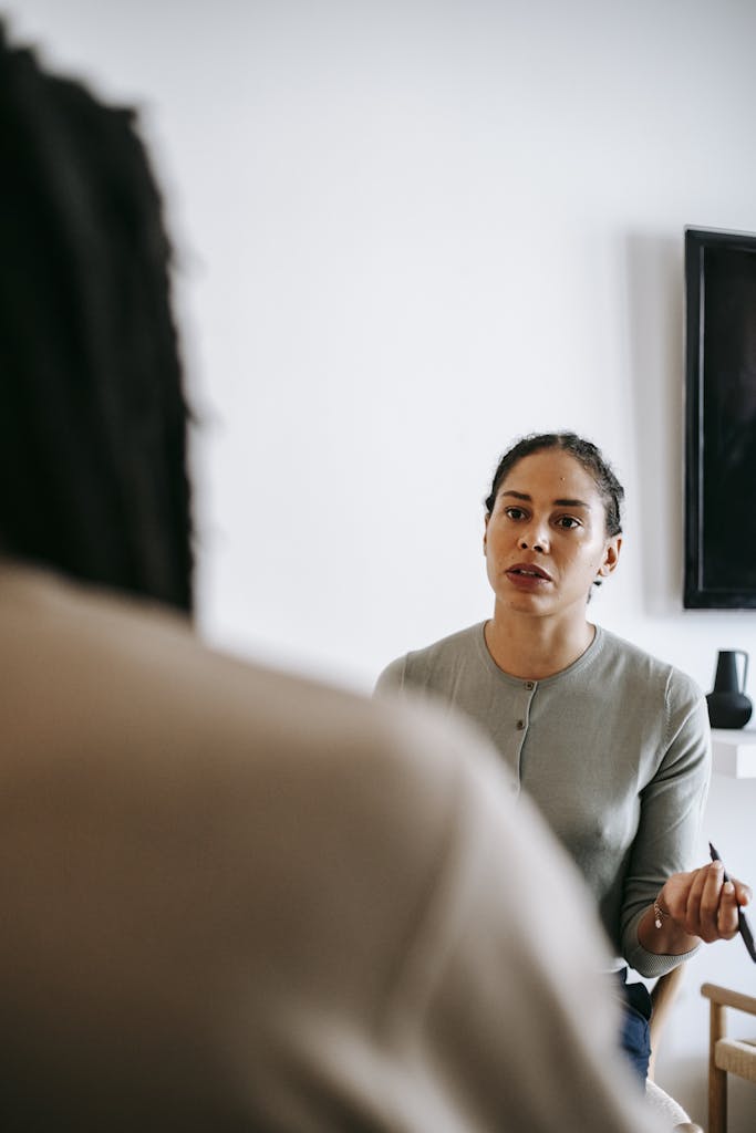 Concentrated ethnic female psychologist talking to client